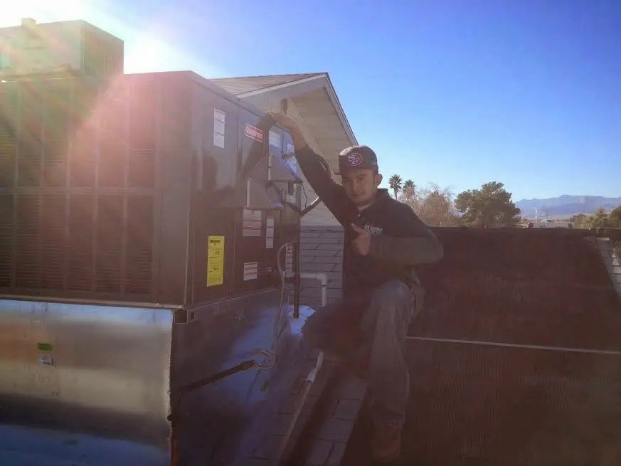 HVAC technician performing HVAC Inspection on a rooftop unit in Bourne